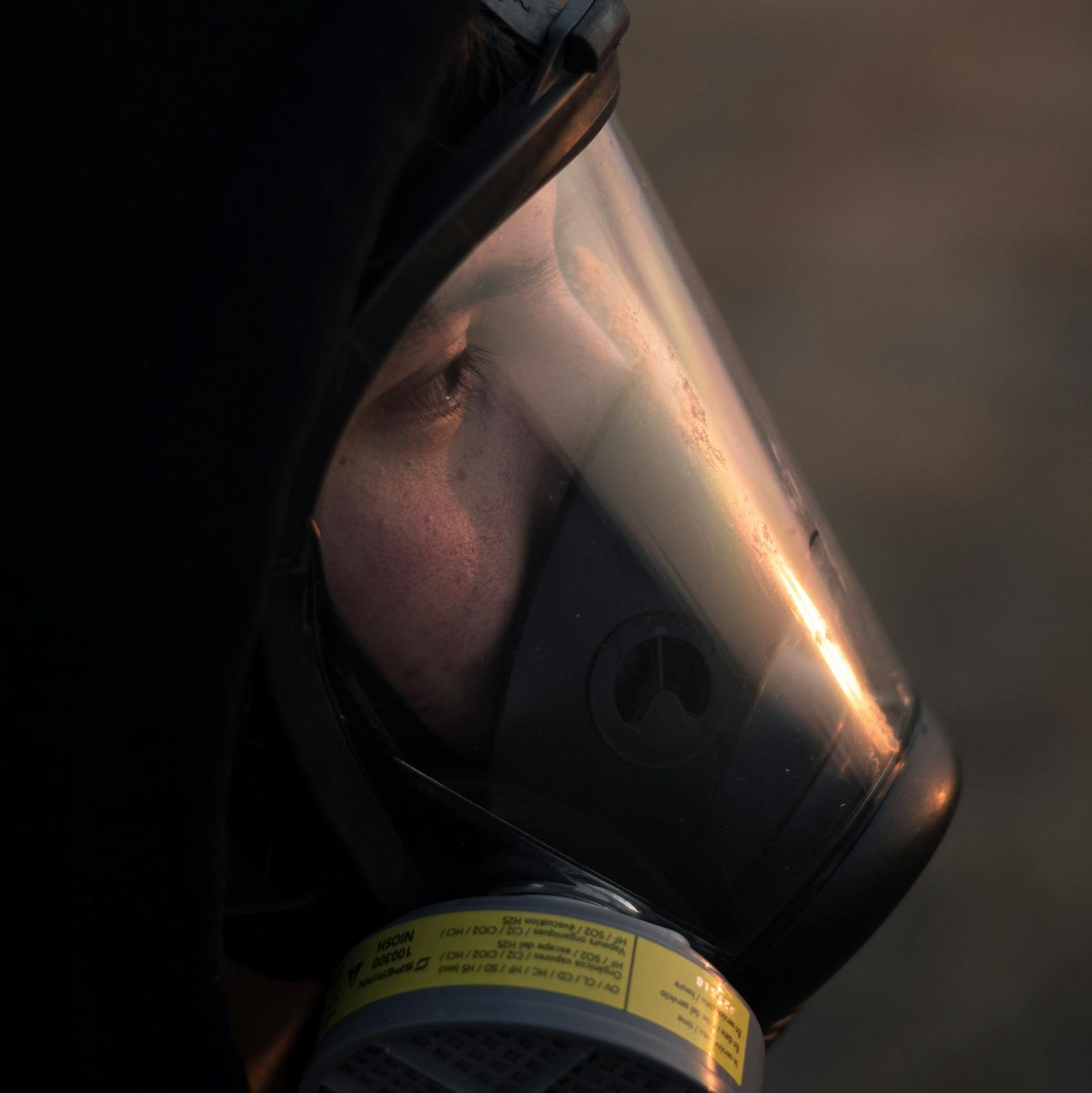 Close-up of a person wearing a gas mask outdoors during dusk in Celaya, Mexico.